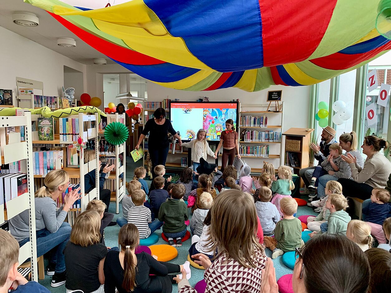 Großer Applaus beim „Karneval im Zoo“: Christina Sürig, Elisa Schwagmeyer und Paula Vlad nach der Vorleseaktion Bild_1_Karneval_im_Zoo_Bilderbuchkino_Stadtbuecherei_Alfeld