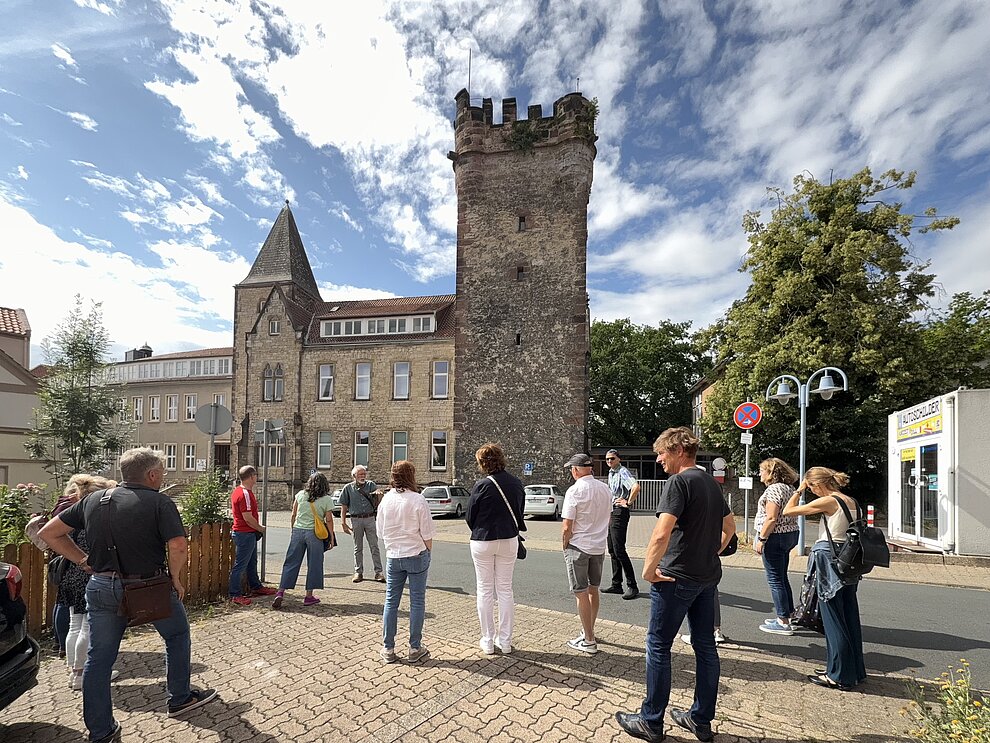 Der Fillerturm ist Alfeld ist ein Ziel der Stadtführungen. Hier sieht man eine Gruppe vor dem Turm bei herrlich weiss-blauem Himmel. © hgscharf