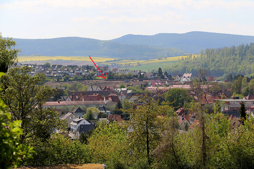 Blick auf das Baugebiet Königsruh (siehe Pfeil): ganz nah an der historischen Altstadt und dennoch mitten im Grünen. © Quintel & Schütz 2018__Koenigsruh_Luftaufnahme_Pfeil