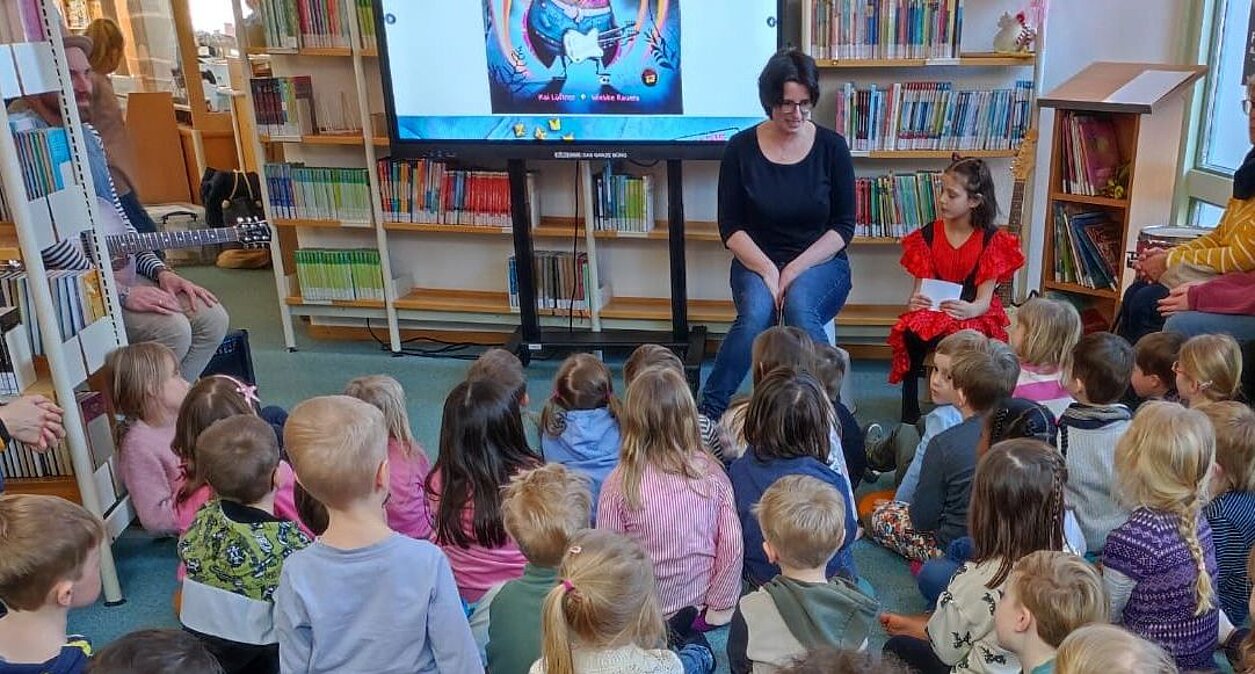 Kinder hören gespannt der Bilderbuchgeschichte "Marie Maikäferchen" in der Stadtbücherei Alfeld zu. Presse_Marie_Kaeferchen_Buecherei_19