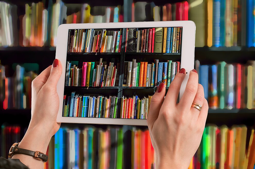 Tablet fotografiert Bücher aus dem Bücherregal